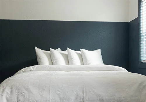 Room with one queen bed and white bedding at Kendall Mountain Lodge
