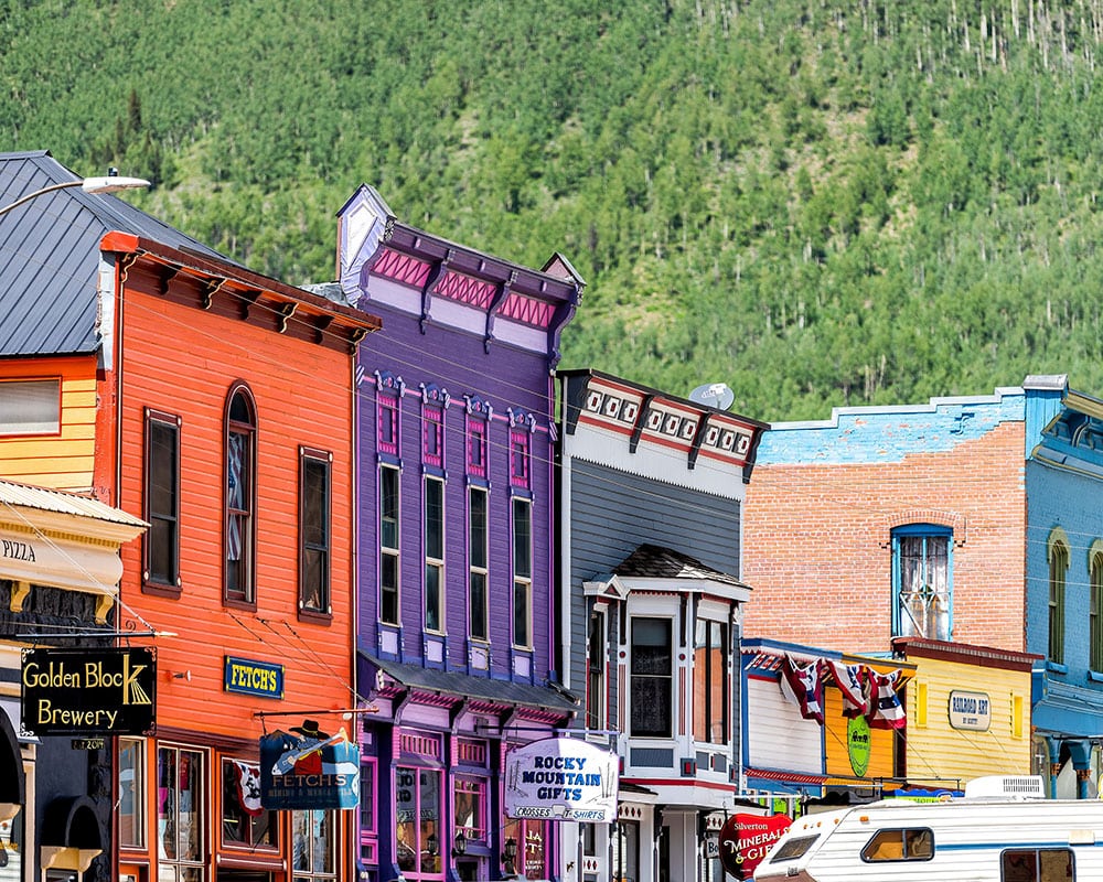 Colorful historic storefronts in downtown Silverton, Colorado, with the San Juan Mountains behind